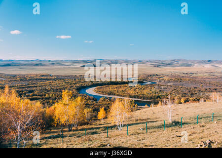 auf einen Berg der Inneren Mongolei Hulun Buir Fluss Genhe Feuchtgebiet in Eergu'Na bekannt als "Asiens erste Feuchtgebiete.", im Herbst mit gelben Bäumen und blauen Himmel Stockfoto