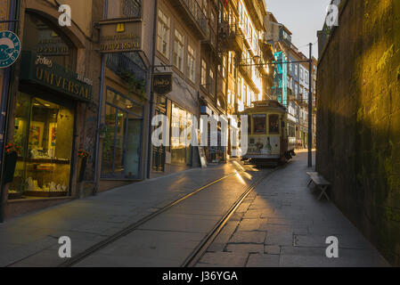 Porto Portugal Zentrum, Blick bei Sonnenuntergang auf eine Straßenbahn, die die Rua da Assuncao im historischen Zentrum von Porto, Portugal, hinunterfährt Stockfoto