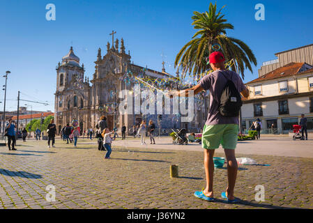 Porto Portugal Stadtzentrum, Kinder haben Spaß Catching Bubbles in der Nähe der Igreja do Carmo in der Praca de Gomez Teixeira Square im Zentrum von Porto Stockfoto