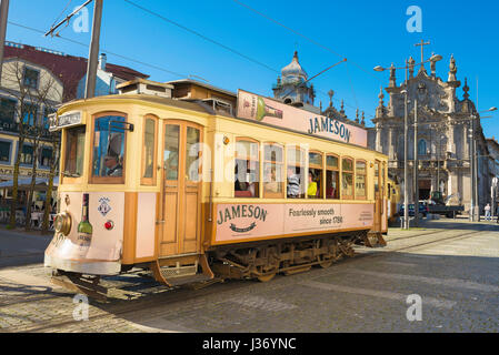 Touristen-Porto-Portugal, fahren Touristen eine Straßenbahn durch das Zentrum von Porto, vorbei an der Igreja Do Carmo in der Praca de Gomez Teixeira, Portugal Stockfoto