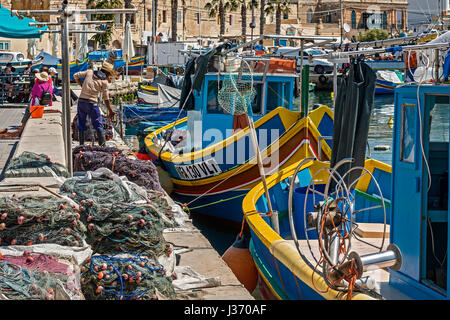 Fischer arbeitet an ihre Netze, Marsaxlokk Dorf, Malta Stockfoto