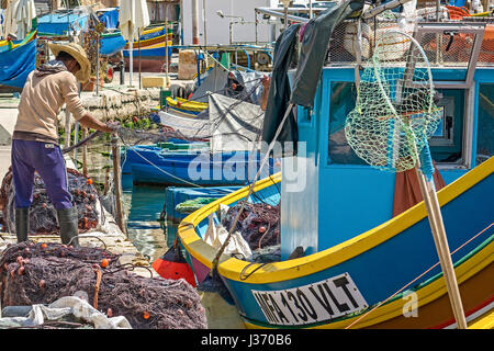 Fischer arbeitet an ihre Netze, Marsaxlokk Dorf, Malta Stockfoto