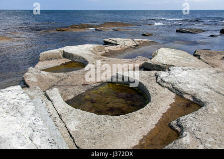 Gislövshammar, kreisförmige Formationen im Fels entlang der Ostsee Küste von Bergbau Mühlsteine für nahe gelegene Getreidemühlen, Österlen, Skane / Scania, Schweden Stockfoto