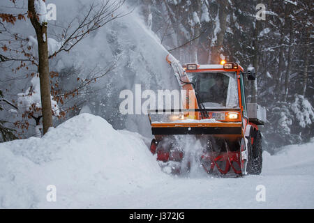 Halter C9700H kommunaler Traktor mit Schneefräse Schneeräumung von Straße im Wald nach starkem Schneefall im winter Stockfoto