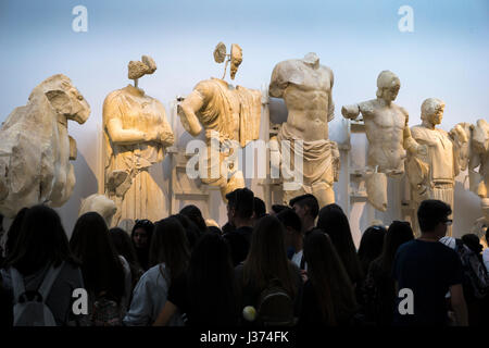 "Die Götter herabsehen", Touristen, die Skulpturen aus der Ostgiebel des Zeustempels anzeigen. Archäologisches Museum, das antike Olympia, Peloponnes, Stockfoto