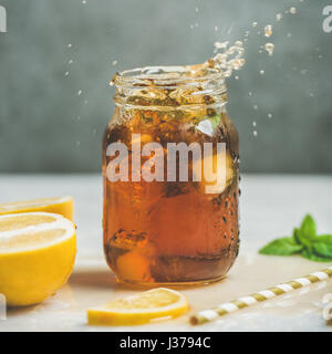 Eistee mit frischen Kräutern in Glas mit Spritzern Stockfoto