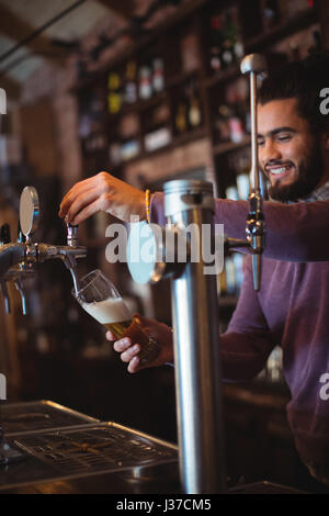 Barkeeper füllen Bier aus bar Pumpe am Tresen Stockfoto