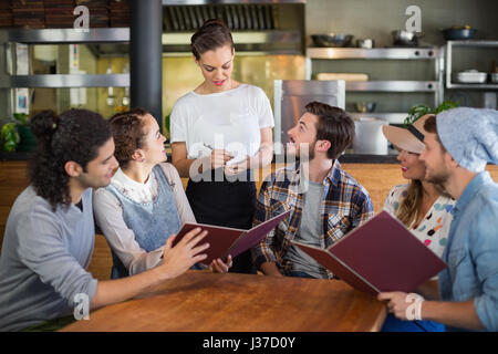 Kunden, die am Abbau der Bestellungen im Restaurant Kellnerin Stockfoto