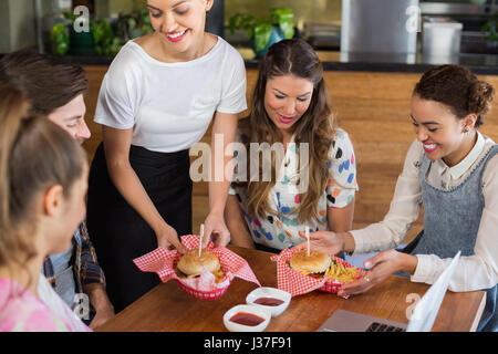Kellnerin, Dienst am Kunden im Restaurant lächelt Stockfoto