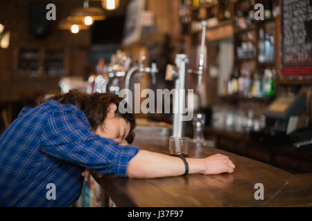 Deprimiert Mann stützte sich auf Zähler im pub Stockfoto