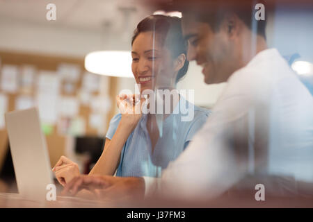 Glücklich Geschäftskollegen sprechen während der Arbeit im Büro durch Glas gesehen Stockfoto