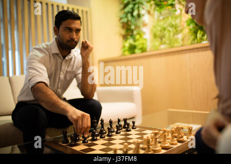 Ernst Kaufmann spielt Schach mit Kollegin im Büro Stockfoto