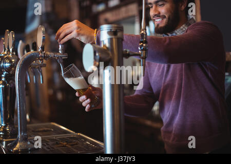 Barkeeper füllen Bier aus bar Pumpe am Tresen Stockfoto