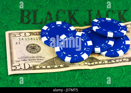 Auf dem grünen Tuch von der Poker-Tisch ist eine Rechnung von $ 50 und fünf Bluechips Stockfoto