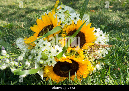 Brautstrauß von Wildpflanzen, Geranien, Sonnenblumen und Brautschuhe Stockfoto