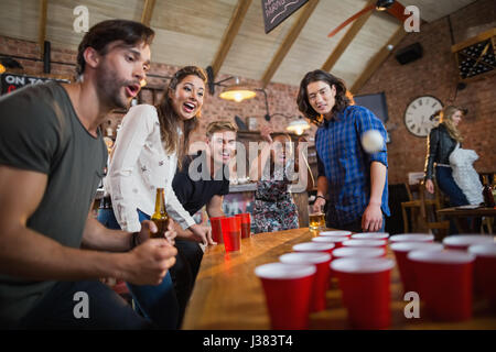 Junge Freunde genießen Bier-Pong-Spiel am Tisch im restaurant Stockfoto