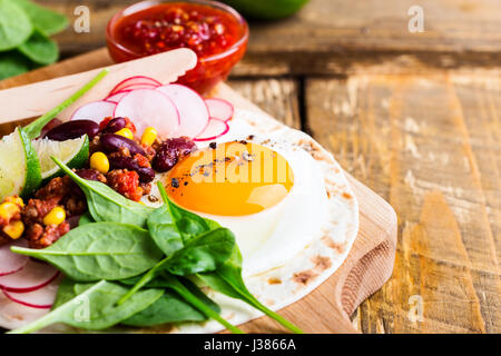 Gebratenes Ei Tacos mit Chili Con Carne auf rustikalen Schneidebrett, traditionelle mexikanische Küche Stockfoto