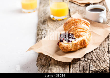 Croissant mit Marmelade und Kaffee Tasse auf Holzbrett, Brunch Tisch Stockfoto