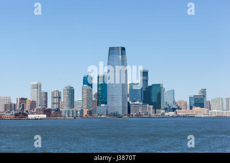JERSEY CITY, NEW JERSEY - 29. März 2017: The Jersey City Skyline wie vom Hudson River zu sehen. Liberty State Park und eine Statue Cruises Fähre Boot ca Stockfoto