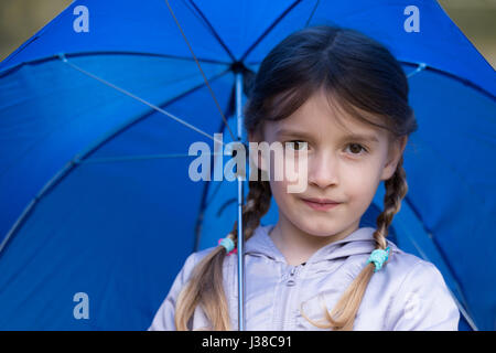 Ein kleines Mädchen mit einem Regenschirm Stockfoto