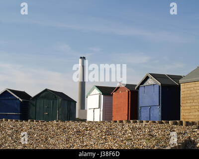 Strandhütten auf Calshot Strand, Southampton, Hampshire mit Fawley Kraftwerk Schornstein im Hintergrund Stockfoto
