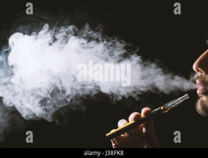 Junger Mann halten und Dampfen eine elektronische Zigarette, e-Cig, Ecigarette. Stockfoto