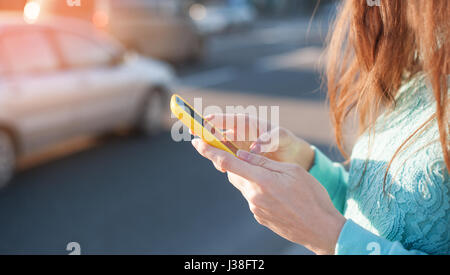 junge Frau mit Smartphone schreibt Stockfoto