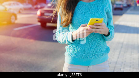 junge Frau mit Smartphone schreibt Stockfoto