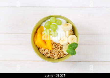 Schüssel mit Müsli mit Joghurt und frischem Obst auf weißem Hintergrund Stockfoto