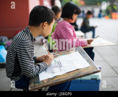 Chengdu - Pixian, Provinz Sichuan, China - 12. April 2015: Kinder lernen in einem Tempel zu zeichnen Stockfoto