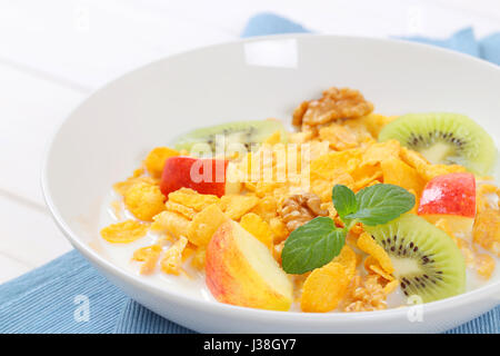 Teller mit Mais Flocken mit Milch und frischem Obst - Nahaufnahme Stockfoto