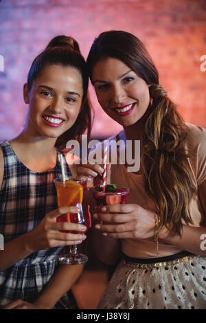 Porträt von zwei jungen Frauen, die Cocktails im pub Stockfoto