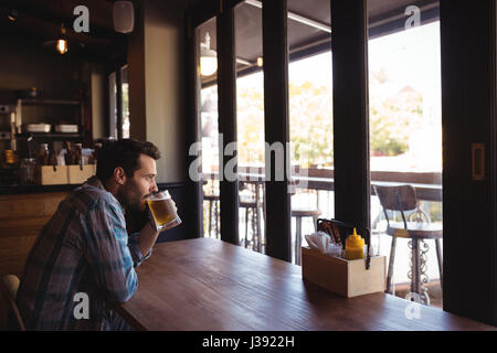 Nachdenklicher Mann mit Bier in der Bar Stockfoto