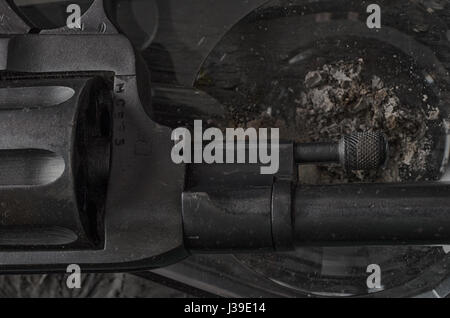 Pistole, Aschenbecher und Rauch. Rauchen kann tödlich sein. Gefahr. Stockfoto