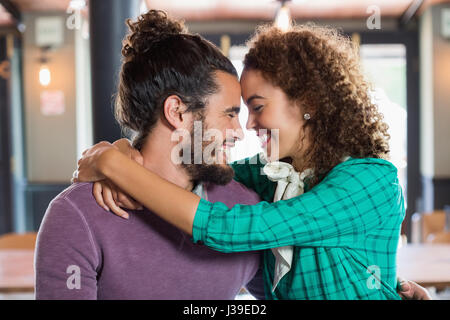 Fröhliches junges Paar umfassend in restaurant Stockfoto