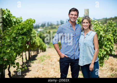 Porträt von junges Paar Stand am Weinberg an sonnigen Tag Stockfoto