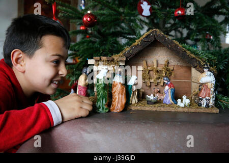 10-Year-Old Boy Verlegung eine Weihnachtskrippe. Stockfoto