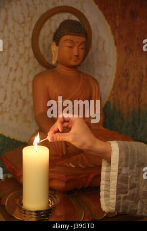 Koreanischer buddhistischer Mönch, eine Kerze anzünden. Stockfoto