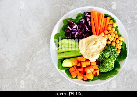 Gesundes Mittagessen Schüssel mit frischem Gemüse und Hummus, Draufsicht auf weißem Marmor Stockfoto