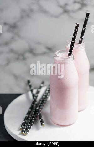Nahaufnahme von zwei Flaschen mit rosa frischen Beeren cocktail am Whiteboard. Stockfoto