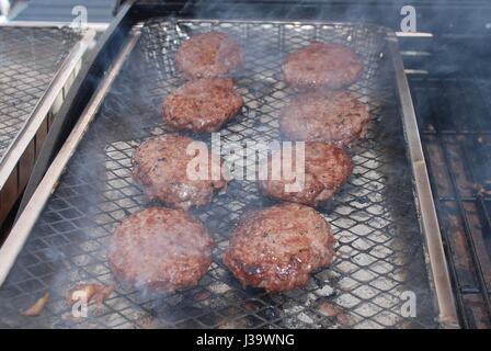 Burger Kochen auf einen Einweg-Grill in der Summer.in der UK Stockfoto