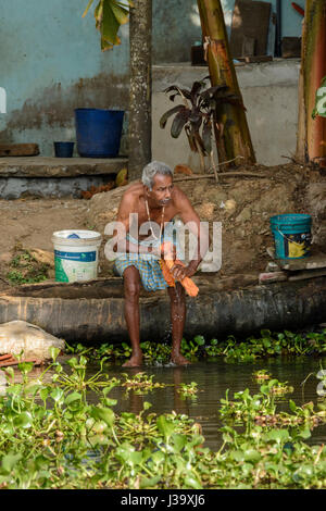 Täglichen Leben: ein Keralas Mann tut seine Wäsche an den Ufern der Kerala Backwaters, Alappuzha Bezirk, Kerala, Süd-Indien, Südasien Stockfoto