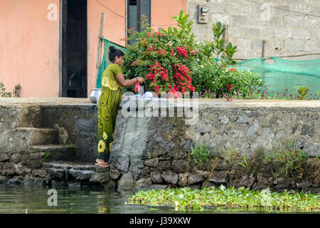 Täglichen Leben: eine Keralas Frau macht ihre Wäsche an den Ufern der Kerala Backwaters, Alappuzha Bezirk, Kerala, Süd-Indien, Südasien Stockfoto