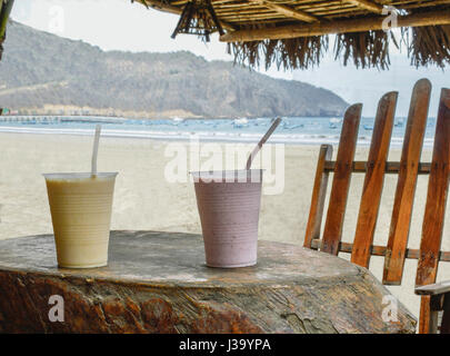 Frische kalte Batidos Fruchtsäfte sitzt auf einem Holztisch auf der Strandterrasse. Stockfoto