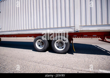 Klassiker der Moderne Container Auflieger mit gewölbten Wänden für Haltbarkeit auf dem langen Orange Metallic flachen Bett Plattform mit Dual tandem Räder Stockfoto