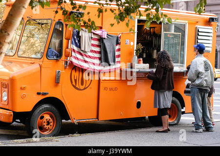 Eine Kaukasische Frau und einem kaukasischen Mann warten auf ihre Nahrung in den Schlamm-LKW, ein Imbisswagen in New York City. Stockfoto