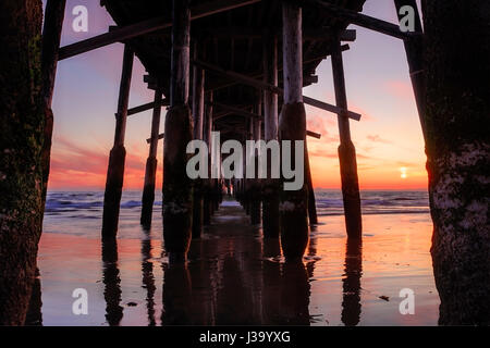 Ein Blick auf den Sonnenuntergang von der unter Newport Beach Pier Stockfoto