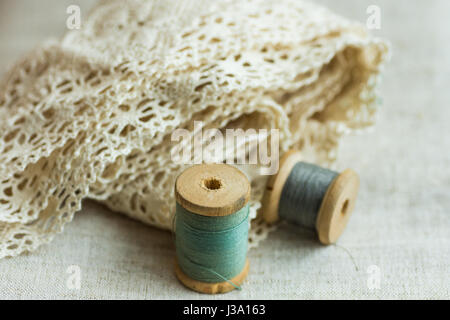 Vintage Holz Spulen mit grünen und grauen Fäden auf Leinenstoff, Baumwollspitze, Schaukel Hobby Konzept, Exemplar, Website-banner Stockfoto