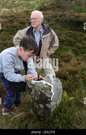Großvater und Enkel Geocaching auf der North Yorkshire Moors, in der Nähe von Captain Cooks Monument. Stockfoto