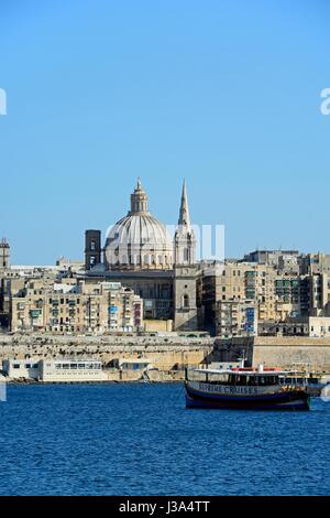 Blick auf Valletta Gebäude der Stadt und Hafen von Marsamxett Harbour mit einem Ausflugsboot in den Vordergrund, Valletta, Malta, Europa gesehen. Stockfoto